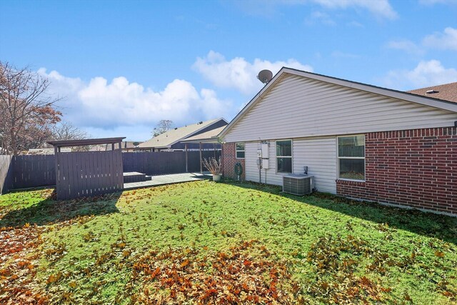 rear view of house featuring a yard and central AC