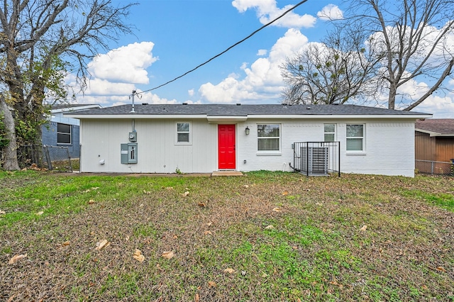 rear view of property featuring a lawn