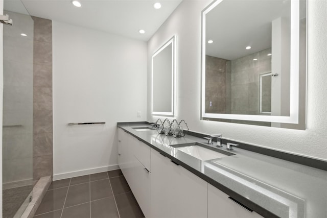 bathroom featuring vanity, tile patterned flooring, and tiled shower