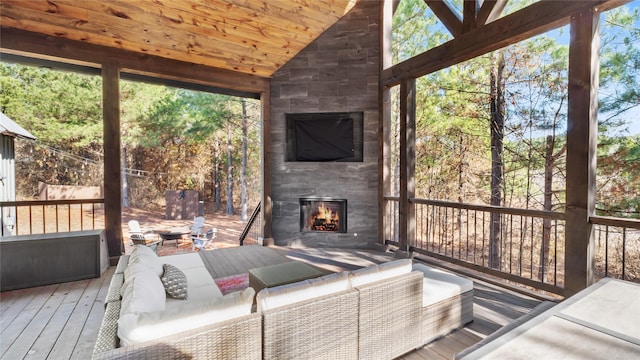 unfurnished sunroom with lofted ceiling, a fireplace, and wooden ceiling