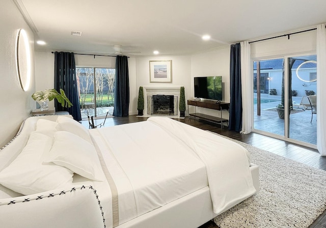 bedroom with access to exterior, dark hardwood / wood-style flooring, and ornamental molding