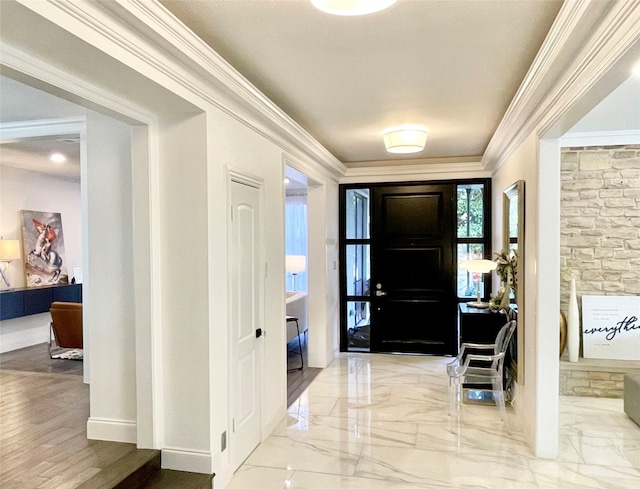 foyer with marble finish floor, baseboards, and crown molding