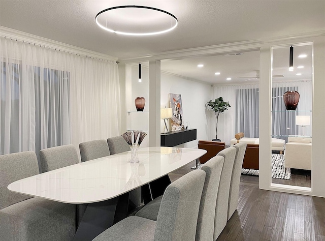 dining space featuring dark hardwood / wood-style flooring, a textured ceiling, and ornamental molding