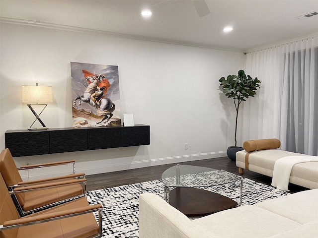 living room with crown molding, dark wood-style flooring, visible vents, and baseboards