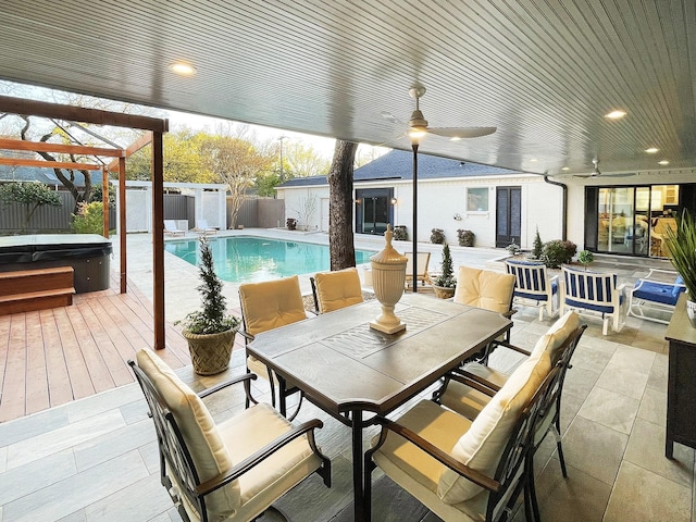 view of patio / terrace featuring a storage unit, ceiling fan, and a pool with hot tub