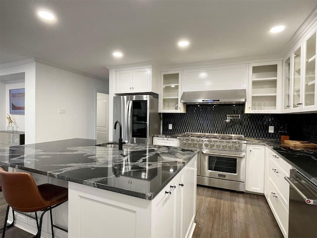 kitchen with a kitchen island with sink, exhaust hood, white cabinetry, and stainless steel appliances