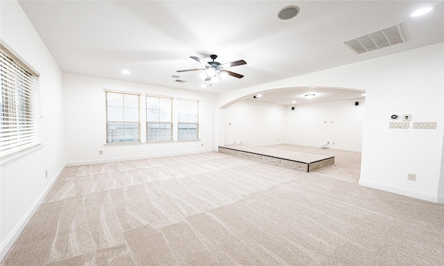 unfurnished living room featuring a wealth of natural light, light carpet, and ceiling fan