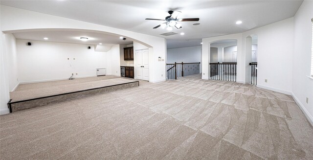 unfurnished living room featuring light colored carpet and ceiling fan