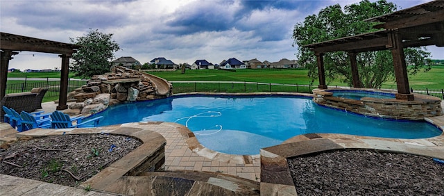 view of pool with an in ground hot tub, a water slide, a yard, and a patio