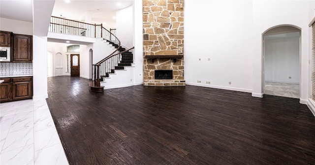 unfurnished living room featuring a high ceiling and a fireplace