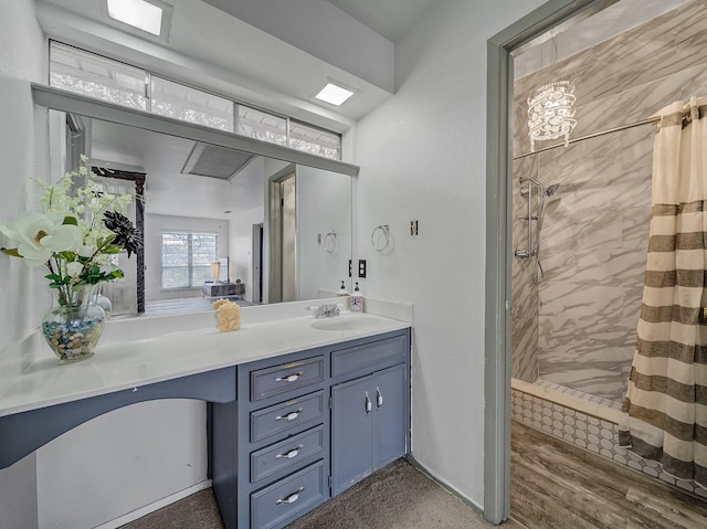 bathroom featuring vanity, wood-type flooring, and tiled shower