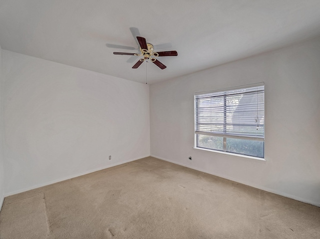 spare room featuring light colored carpet and ceiling fan