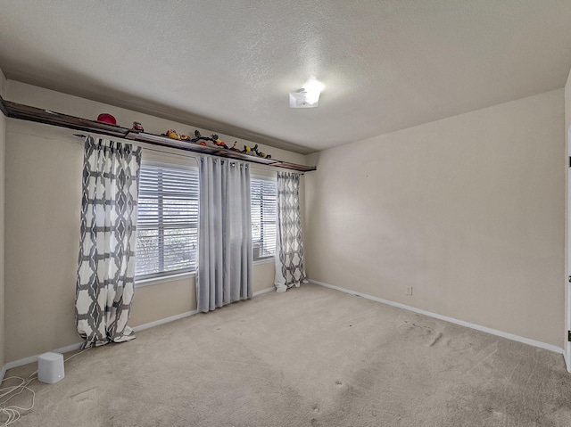 carpeted empty room featuring a textured ceiling