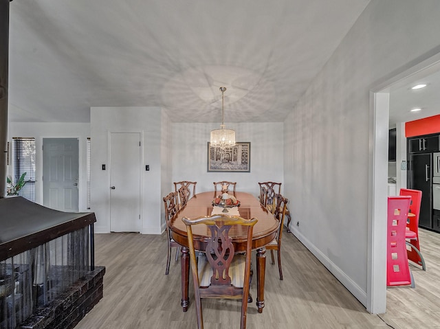 dining area with a notable chandelier and light hardwood / wood-style flooring