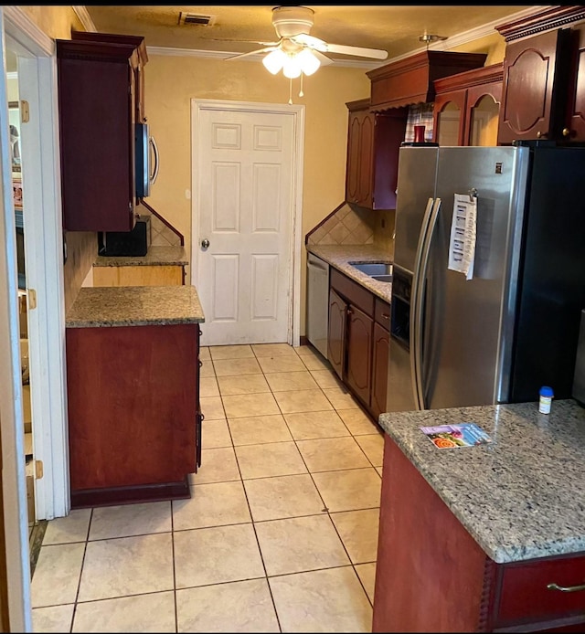 kitchen with ceiling fan, crown molding, decorative backsplash, light tile patterned floors, and appliances with stainless steel finishes