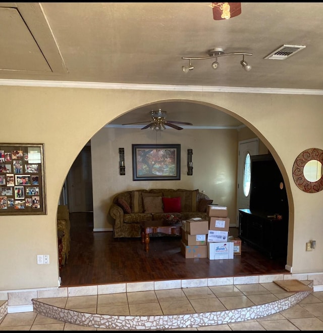 living room featuring hardwood / wood-style flooring, ceiling fan, and ornamental molding