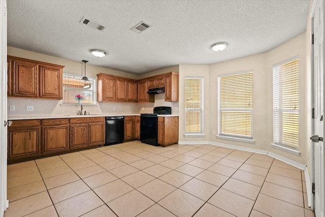 kitchen with sink, a textured ceiling, light tile patterned floors, pendant lighting, and black appliances