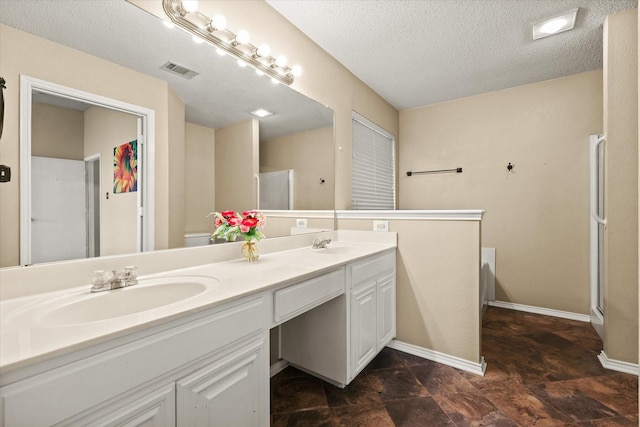 bathroom with vanity, a washtub, and a textured ceiling