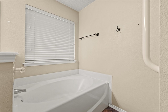 bathroom with a bathtub and a textured ceiling