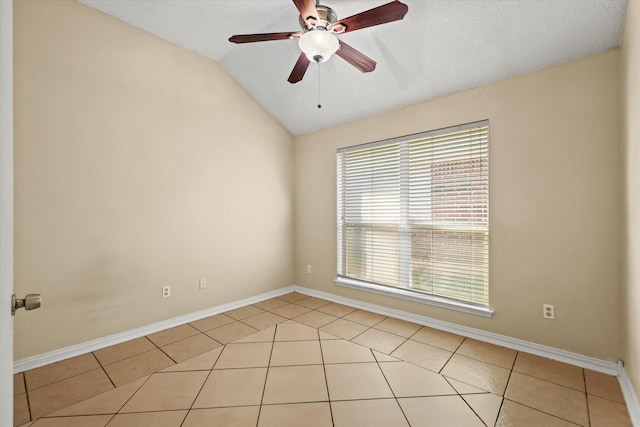 spare room with vaulted ceiling, light tile patterned floors, and ceiling fan