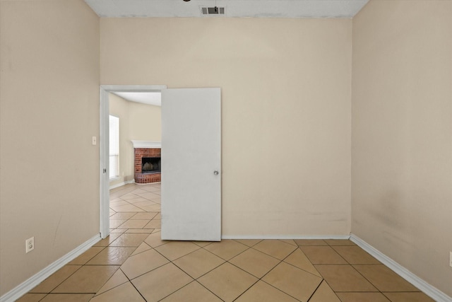 tiled spare room featuring a fireplace