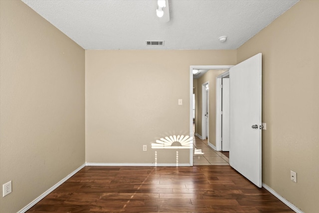 spare room with dark wood-type flooring and a textured ceiling