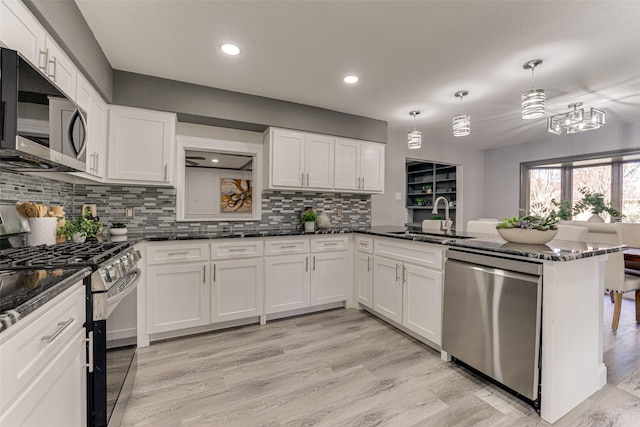 5503 Pecan Grove Dr, Sachse, TX 75048 - kitchen with stainless steel appliances, a sink, a peninsula, white cabinets, and recessed lighting