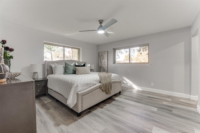 bedroom featuring multiple windows, ceiling fan, and wood-type flooring