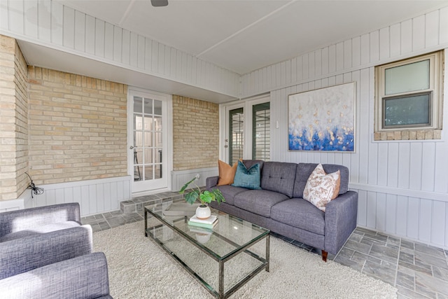 living room featuring wooden walls and brick wall