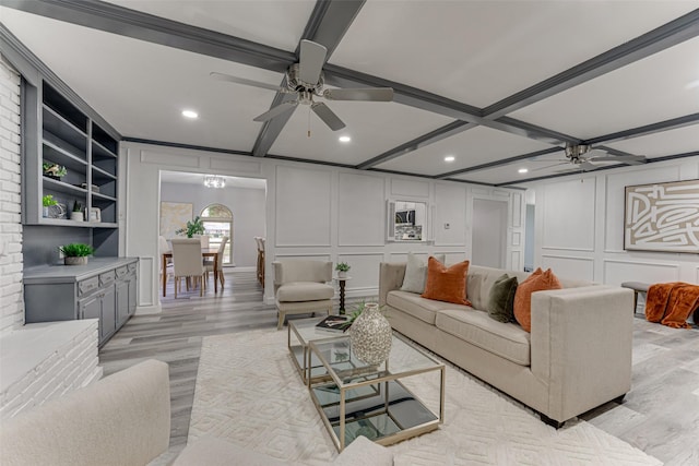 living room featuring light hardwood / wood-style flooring, beamed ceiling, and ceiling fan with notable chandelier