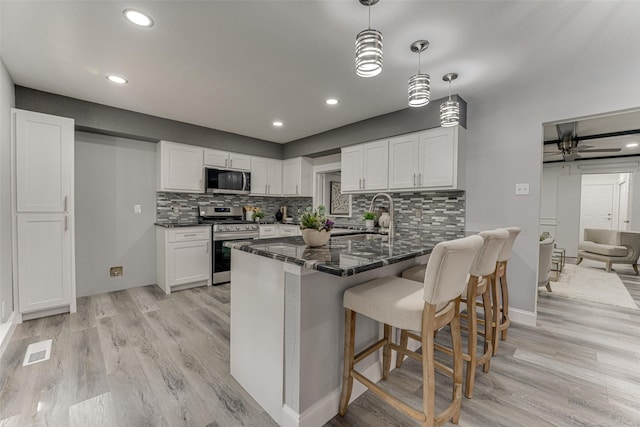 5503 Pecan Grove Dr, Sachse, TX 75048 - kitchen featuring appliances with stainless steel finishes, light wood-style floors, white cabinets, and recessed lighting