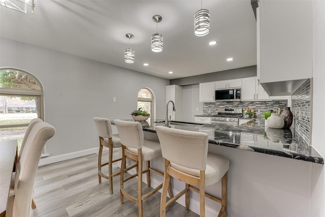 5503 Pecan Grove Dr, Sachse, TX 75048 - kitchen featuring appliances with stainless steel finishes, backsplash, dark stone countertops, white cabinets, and healthy amount of natural light