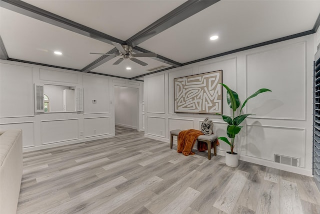 spare room with ceiling fan, light hardwood / wood-style floors, ornamental molding, and beam ceiling