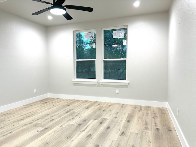 spare room with ceiling fan and light wood-type flooring