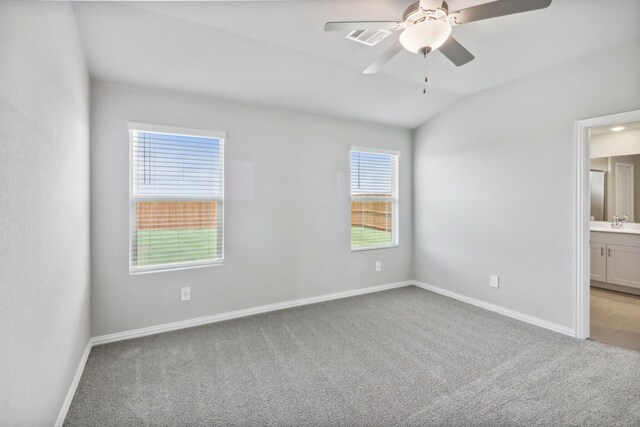 carpeted empty room with ceiling fan, sink, and lofted ceiling