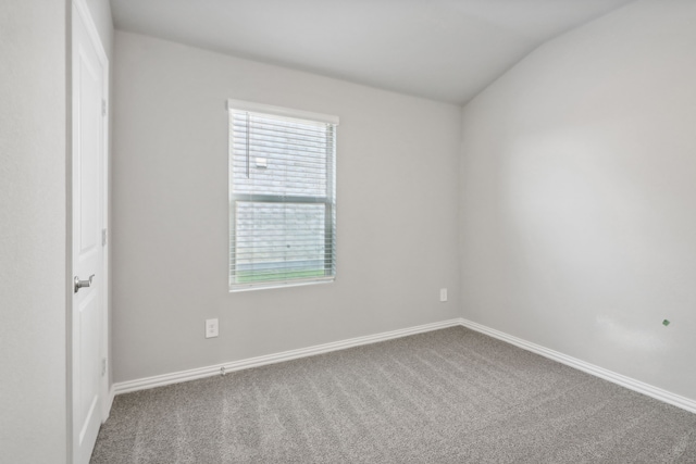 empty room with carpet flooring and lofted ceiling