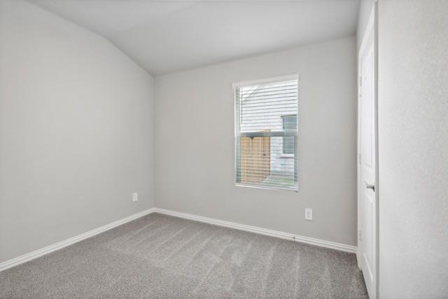 carpeted spare room featuring lofted ceiling