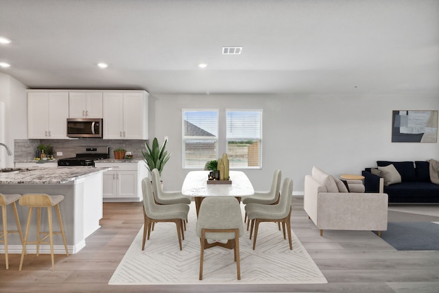 dining area with light hardwood / wood-style flooring and sink