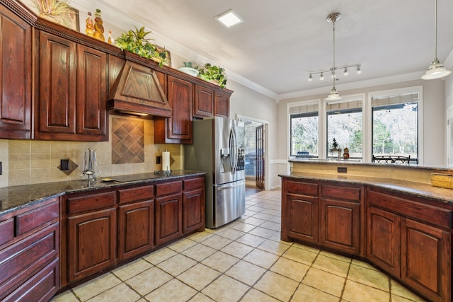 kitchen with stainless steel refrigerator with ice dispenser, backsplash, ornamental molding, custom exhaust hood, and hanging light fixtures