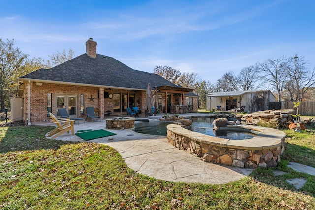 back of property featuring a fire pit and a patio