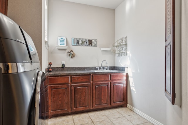 kitchen featuring stainless steel fridge, sink, and light tile patterned floors