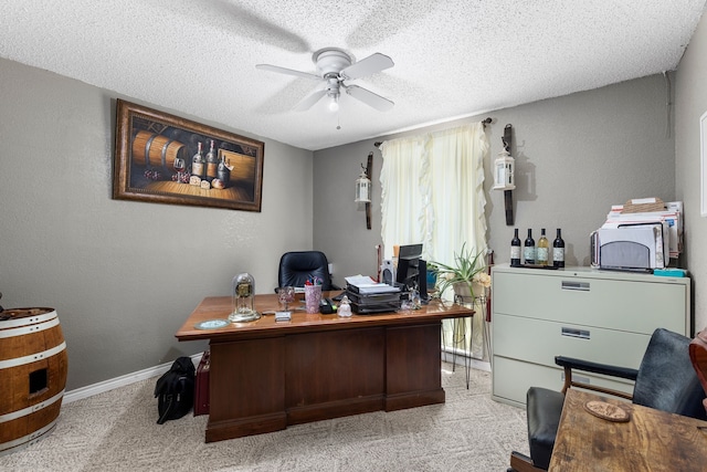 carpeted office space with ceiling fan and a textured ceiling