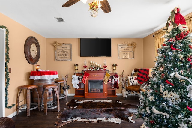 living room with ceiling fan and dark wood-type flooring