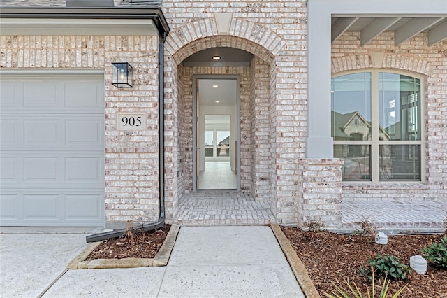 view of exterior entry featuring brick siding