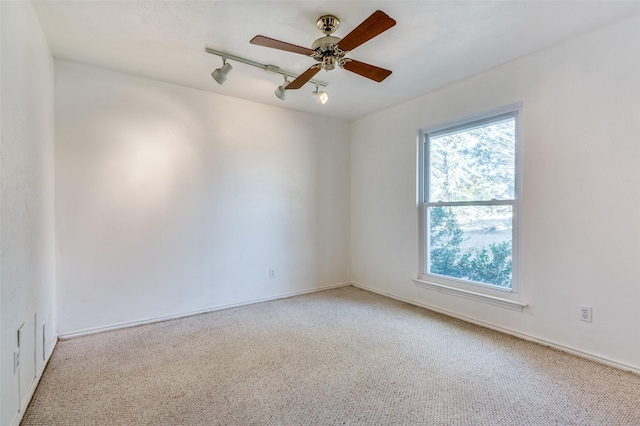 unfurnished room with rail lighting, light colored carpet, and ceiling fan