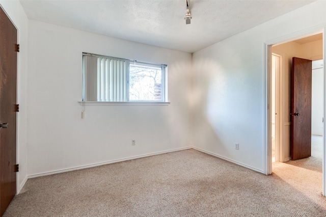 spare room featuring carpet and a textured ceiling