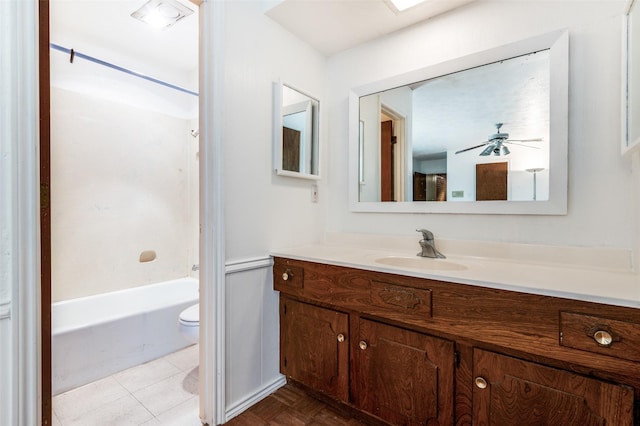 full bathroom with ceiling fan, washtub / shower combination, tile patterned flooring, toilet, and vanity