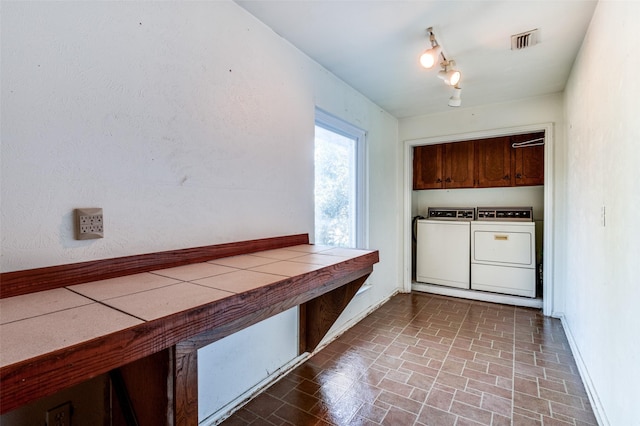 laundry area with cabinets, independent washer and dryer, and track lighting