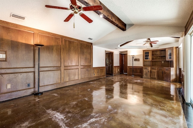 interior space featuring ceiling fan, lofted ceiling with beams, and a textured ceiling