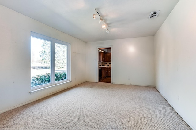 carpeted empty room with track lighting